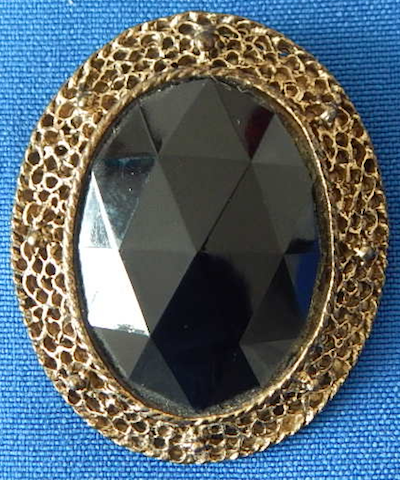 Big black faceted glass in brass pin